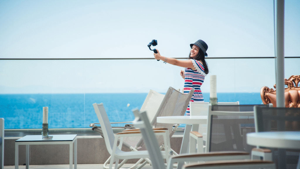A woman is taking a video with their Phone near the beach