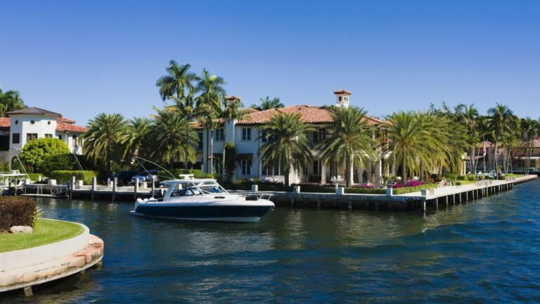 a boat is docked in front of a house on the water