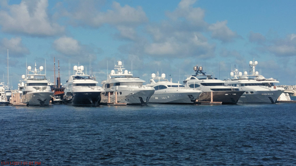 Many luxury yachts are docked at a marina