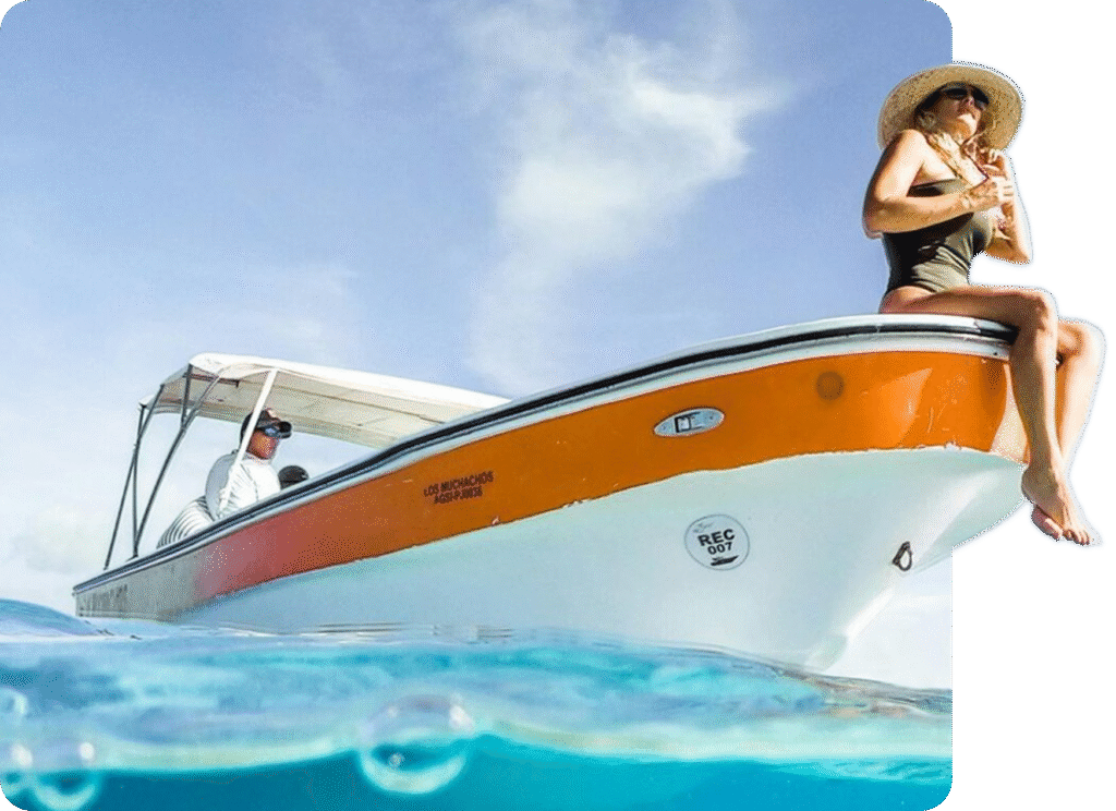 A woman sitting on the nose of the sailboat while sailing